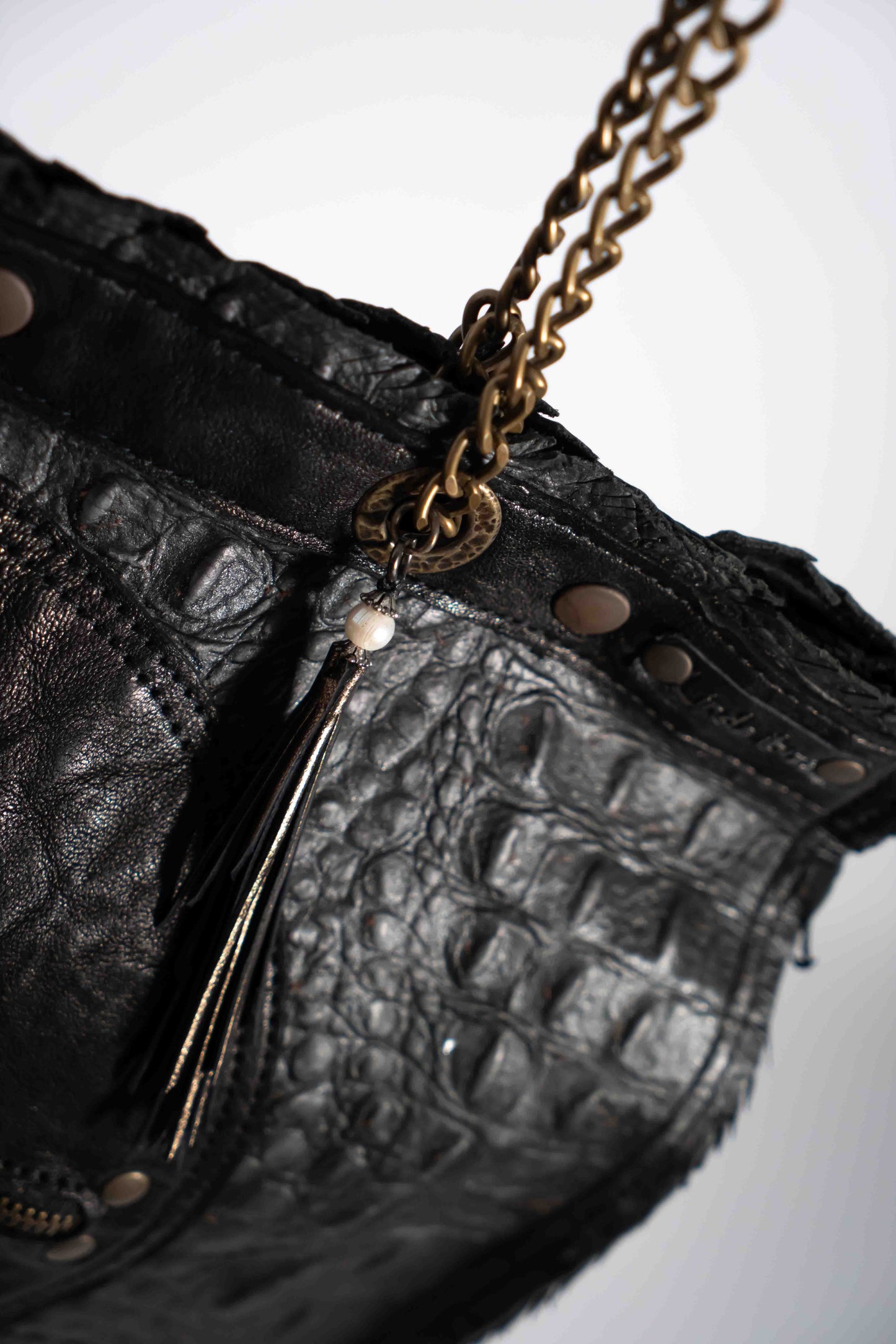 Handmade textured black leather shopping bag with chain and leather straps.