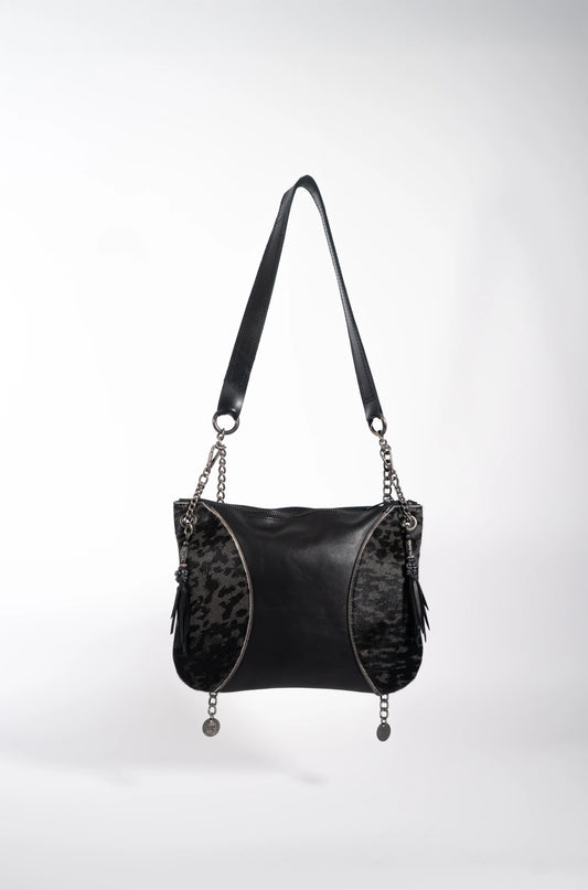 Artisan fringe, bead, and coin hanging accessories on the handmade black leather bag.