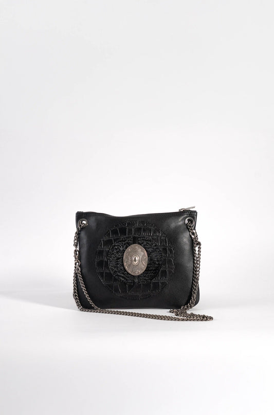 Luxury handcrafted black leather bag with a silver medallion, artisan design from Linda Ibiza.