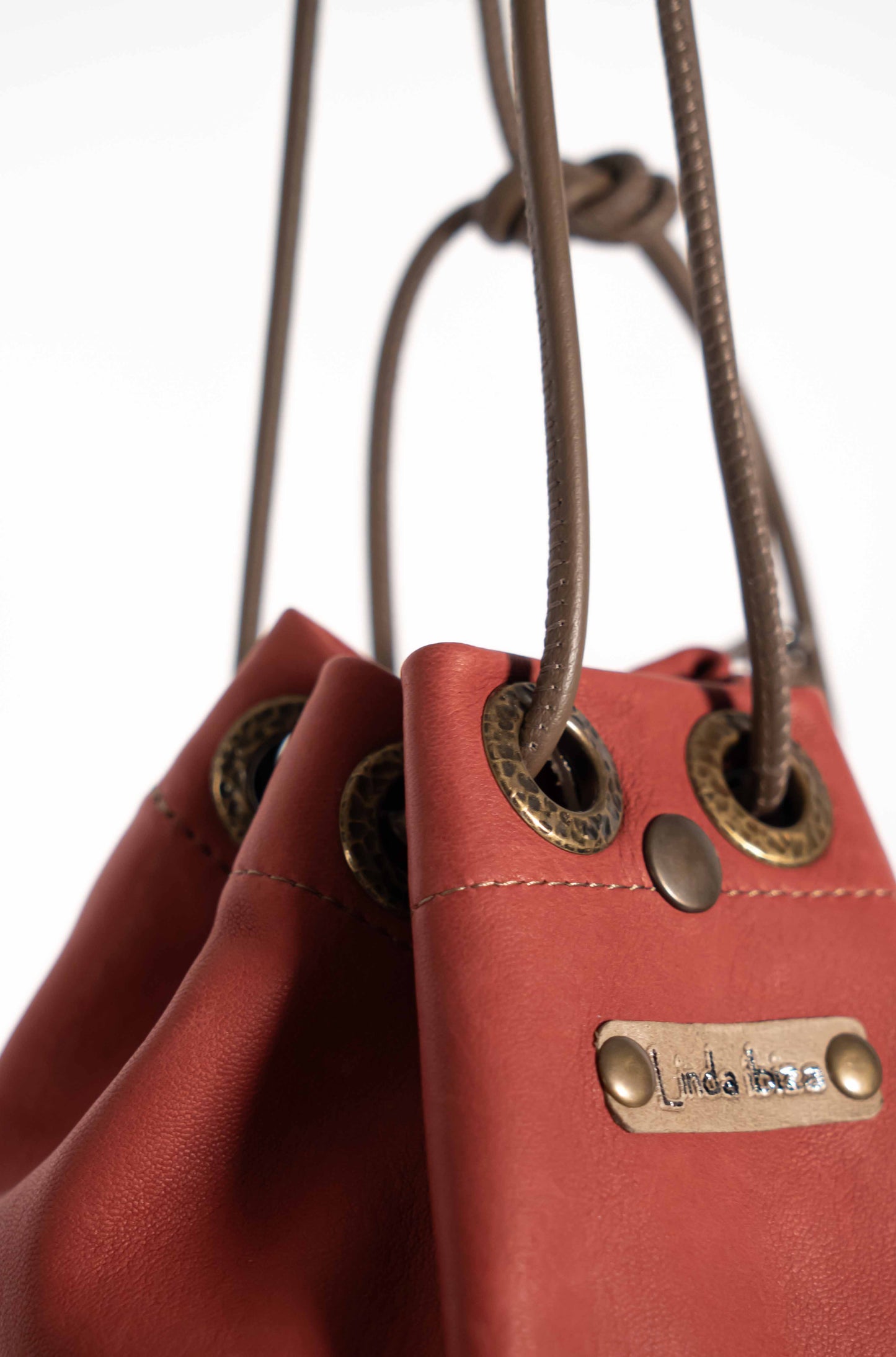 Boho-chic red leather crossbody bag styled for a sophisticated Mediterranean look.