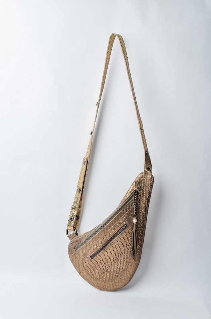 Boho-chic gold leather sling bag styled for a sophisticated Mediterranean look.