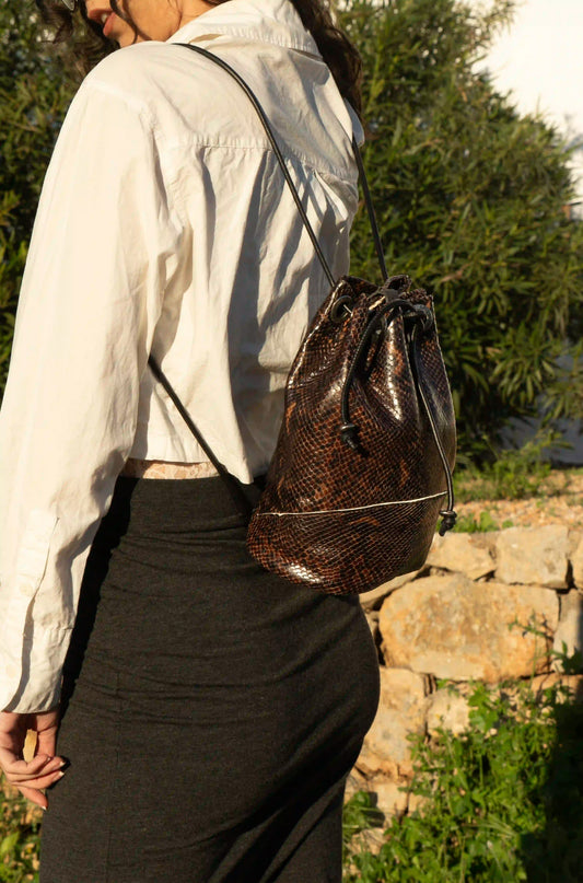 Premium chocolate brown leather bag with snake texture, handcrafted in Ibiza with a 3-in-1 multifunction design.