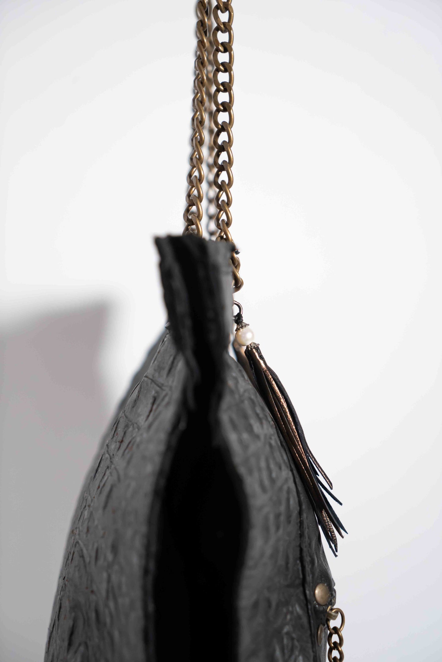 Handmade textured black leather shopping bag with chain and leather straps.