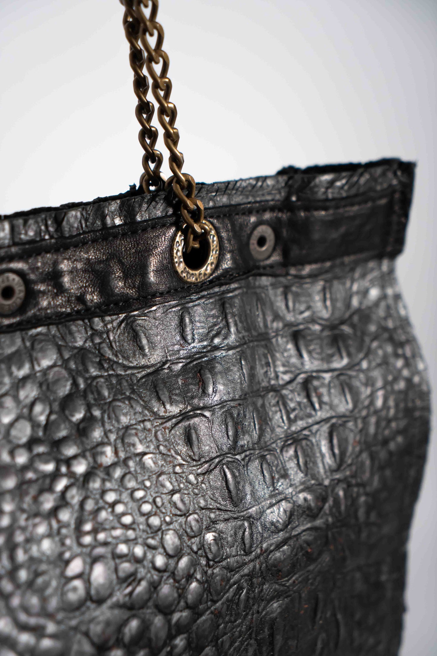 Handmade textured black leather shopping bag with chain and leather straps.
