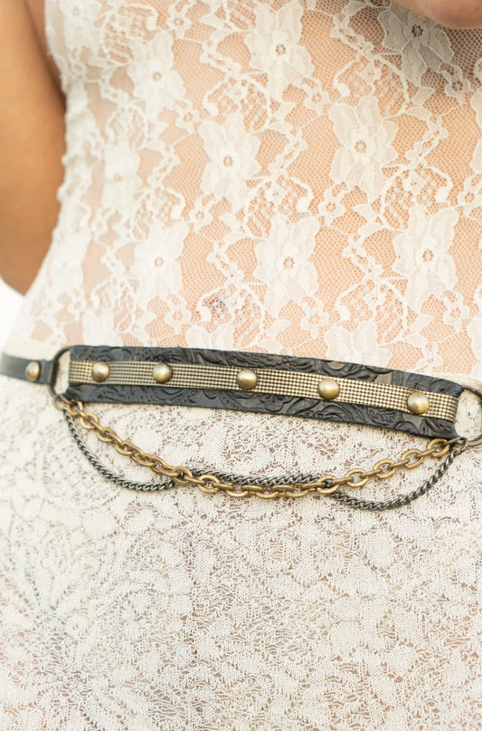 Elegant boho-chic look with a black floral leather belt on a white dress, authentic Ibiza handmade fashion.