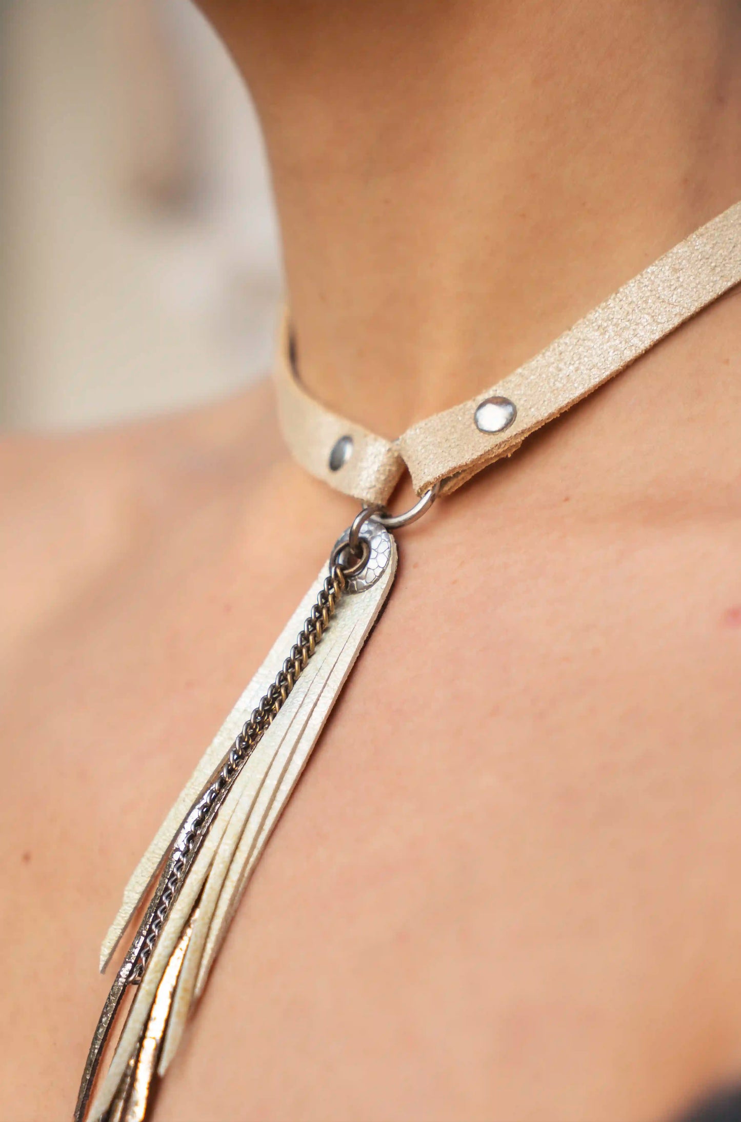 Close-up of the gold fringe detail and leather strap of the Ibiza necklace.