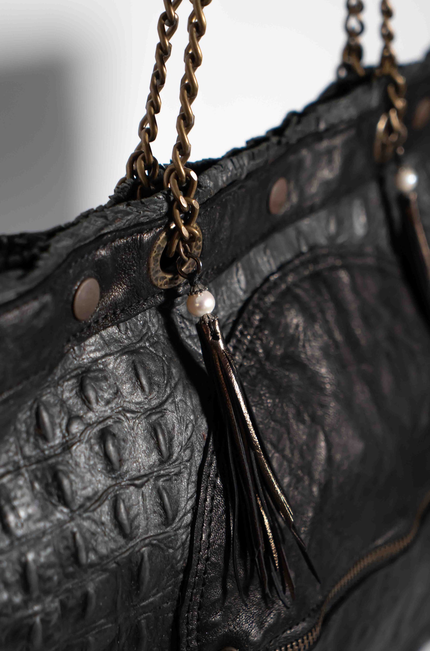 Handmade textured black leather shopping bag with chain and leather straps.