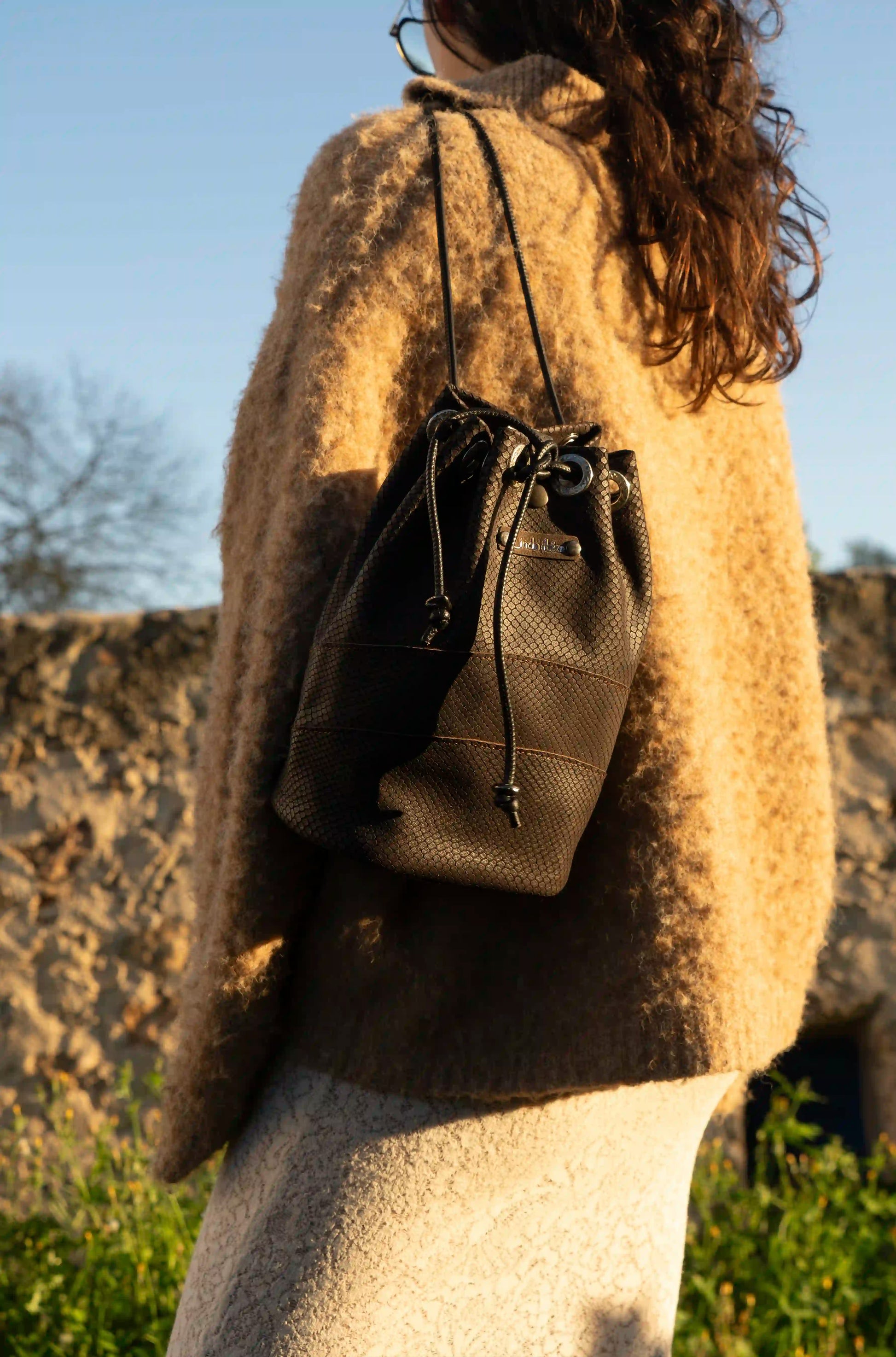Side view of the multifunction premium leather bag, featuring adjustable straps for shoulder or crossbody wear.