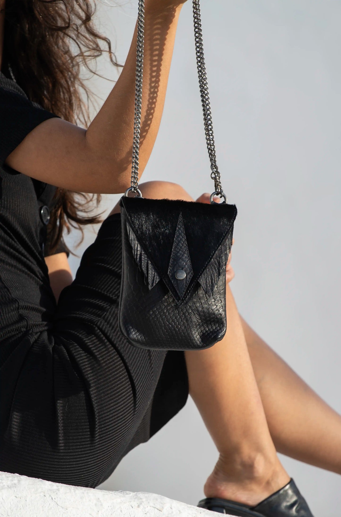 Handmade black premium leather small bag with snake texture and fringe details, handcrafted in Ibiza by Linda Ibiza Design.
